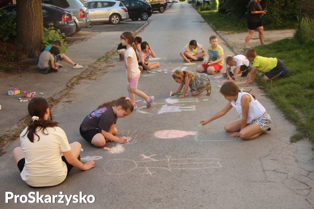 Dzieci malujące kredą po asfalcie