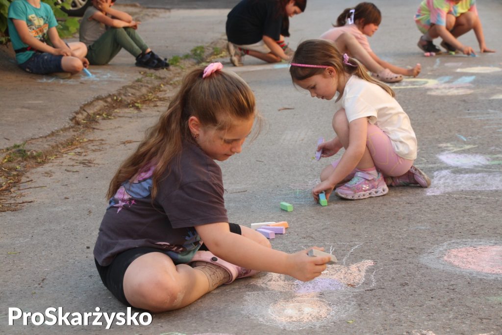 Dzieci malujące kredą po asfalcie