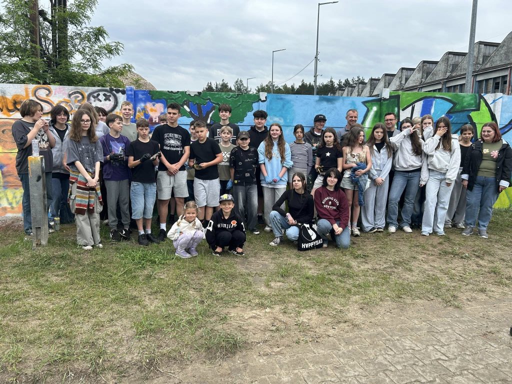 Zdjęcie osób, które wykonują graffiti na muralu