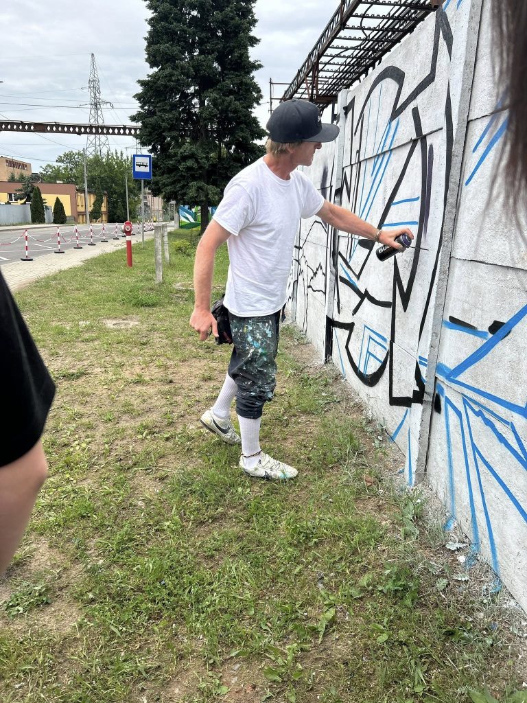 Zdjęcie osób, które wykonują graffiti na muralu