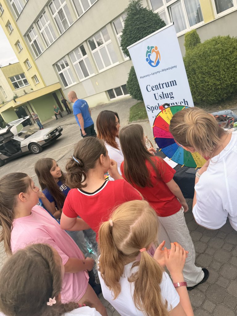 Grupa osób, która bierze udział w festynie z okazji Dnia Dziecka