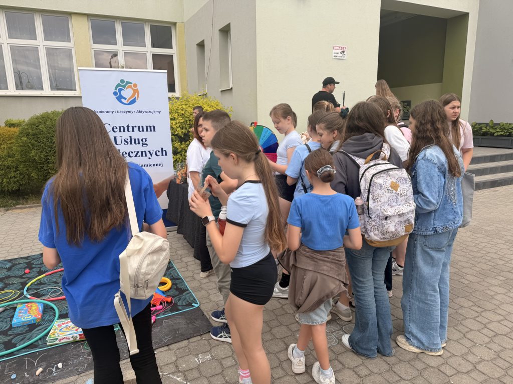 Grupa osób, która bierze udział w festynie z okazji Dnia Dziecka