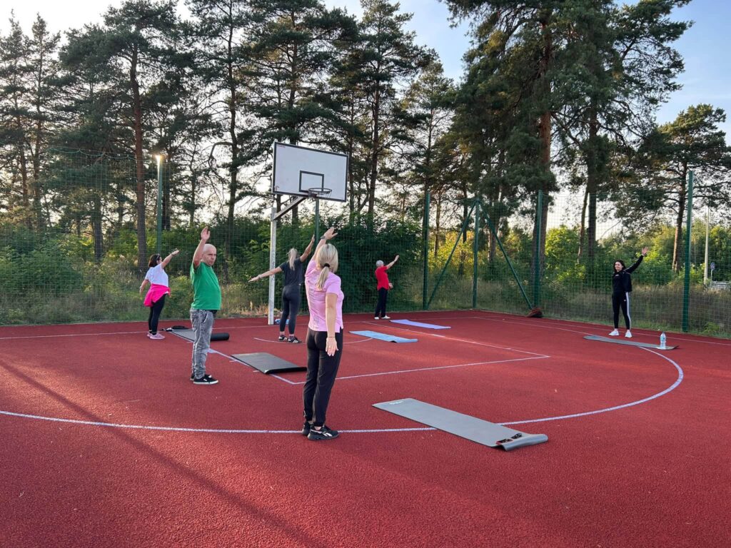 Osoby uczestniczące w aerobiku w plenerze